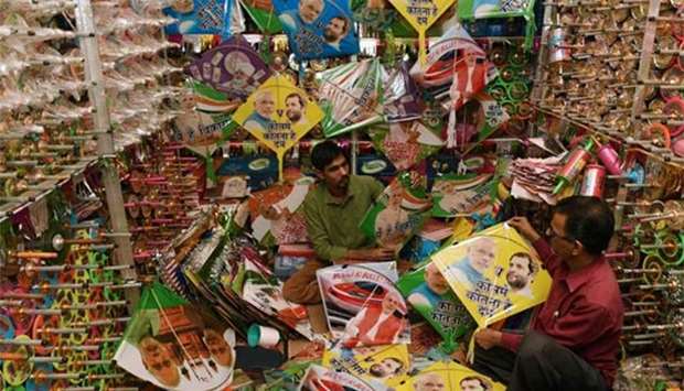 Indian kite maker Salimbhai Rasulbhai Patangwala (left) shows kites with photos of Indian Prime Minister Narendra Modi and Congress Vice President Rahul Gandhi to a customer at his shop ahead of Gujarat's legislative assembly election, in Ahmedabad on Thursday.
