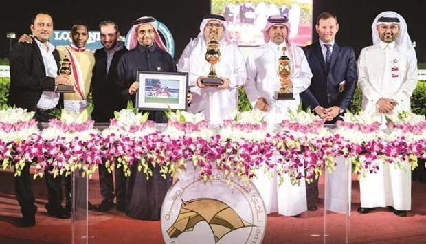 Winners of the Thoroughbred Guineas (Group 3) with their respective trophies after Abdulatif Hussain al-Emadi-owned Pazeer won the race at the Qatar Racing and Equestrian Club yesterday. PICTURES: Juhaim