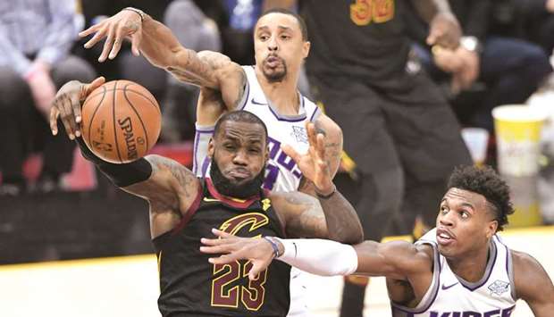 Cavaliers forward LeBron James (left) reaches for a rebound as Sacramento Kings guards George Hill and Buddy Hield (right) attempt to block during the NBA game at Quicken Loans Arena in Cleveland, Ohi, on Wednesday night. (USA TODAY Sports)