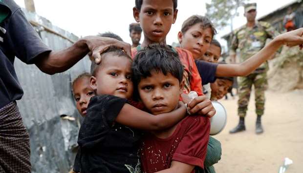 Rohingya refugees wait for cooked food to be distributed at Tengkhali camp near Cox's Bazar, Bangladesh. Reuters