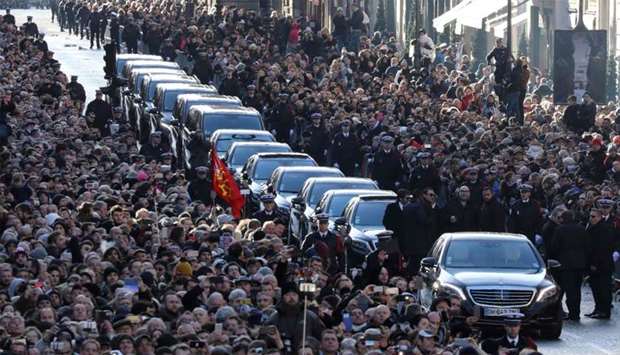 People gather outside the La Madeleine Church prior to the funeral ceremony in tribute to late French singer Johnny Hallyday