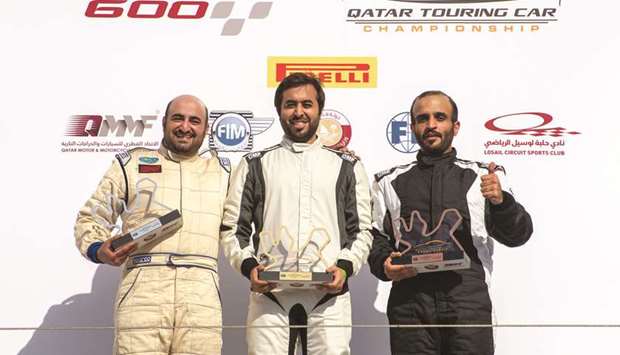 Winner Abdulla al-Khelaifi (centre) poses with second-placed Ahmed al-Asiri (left) and third-placed Hamad al-Sulaiti on the podium for the first race of the opening round of the Qatar Touring Car Championship (QTCC) at the Losail International Circuit.