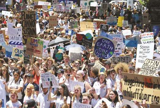 Thousands of children hold placards and chant slogans after they walked out of school in protest against government inaction on climate change in Sydney, Australia.