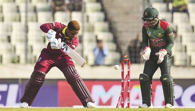 West Indiesu2019 Shimron Hetmyer (left) is clean bowled as Bangladeshu2019s Mushfiqur Rahim looks on during the first ODI in Dhaka yesterday. (AFP)
