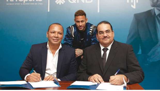 Yousef Darwish, General Manager of QNB Group Communications (R), and Neymar Silva Santos (L), the owner of NR Sport & Marketing, sign the agreement in Paris in the presence of Brazil and PSG starNeymar Jr. At right, Darwish with Neymar Jr.
