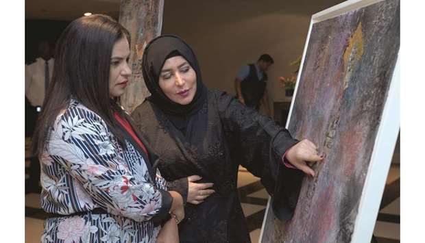 ABSTRACT WORK: Hessa Kalla, artist, giving an insight to a visitor about her abstract paintings and composition. Photos by Ram Chand