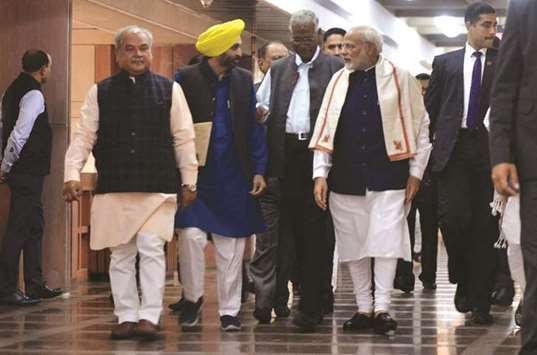 Prime Minister Narendra Modi speaks with Aam Aadmi Party MP Bhagwant Mann and Communist Party of India MP D Raja as they arrive for an all-party meeting ahead of the winter session of parliament, in New Delhi yesterday.
