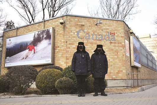 Chinese police officers stand guard outside the Canadian embassy in Beijing.
