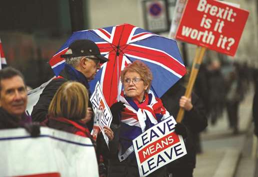 Pro and anti-Brexit demonstrators stand outside the Houses of Parliament in London yesterday.