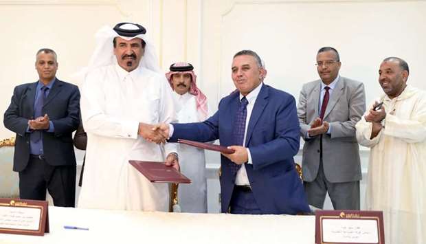 QC first vice-chairman Mohamed bin Ahmed bin Towar and head of the Moroccan Chamber for Handicrafts in Souss-Massa region, Affane Ben Bouaida shake hands after signing the agreement