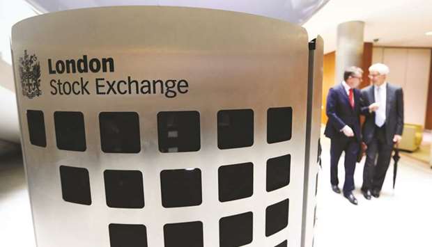 Visitors pass a sign inside the main atrium of the London Stock Exchange headquarters. The FTSE 100 closed up 1.3% to 6,806.94 points yesterday.