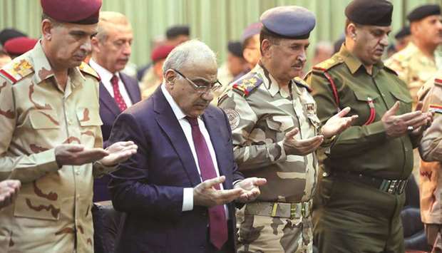 This handout picture released by the Iraqi prime ministeru2019s press office yesterday shows PM Adel Abdel Mahdi praying with military figures during a ceremony held in the capital Baghdad, on the first anniversary of the countryu2019s victory over the Islamic State (IS) group.