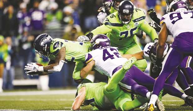 Seattle Seahawks Chris Carson dives passed Ben Gedeon (No 42) of the Minnesota Vikings for a touchdown in the fourth quarter in Seattle. (Getty Images/TNS)