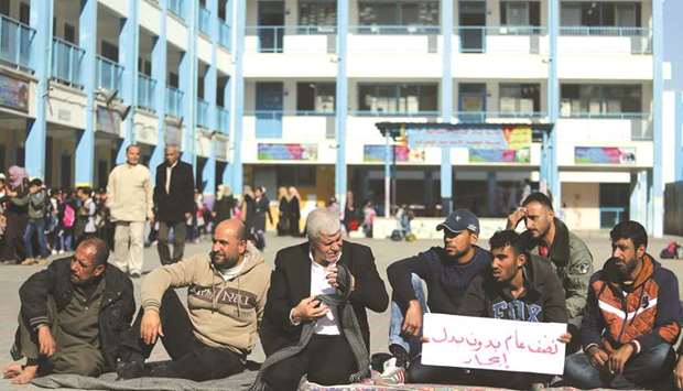 Palestinians whose houses were destroyed during 2014 war, sit at a United Nations-run school where they try to take refuge to protest against UNRWAu2019s decision to stop paying rents, in the northern Gaza Strip, yesterday.