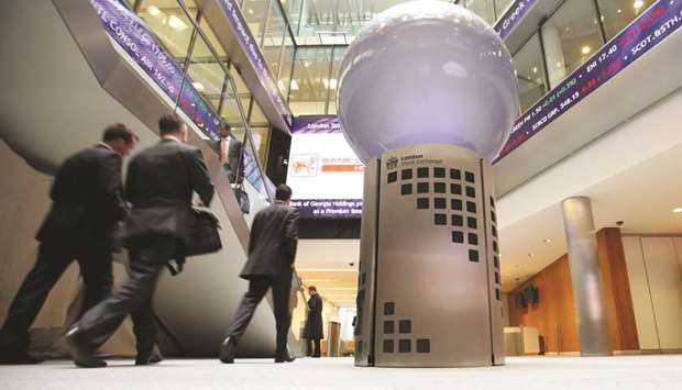Visitors pass a sign inside the London Stock Exchange. The FTSE 100 closed down 1.0% to 6,970.78 points yesterday.