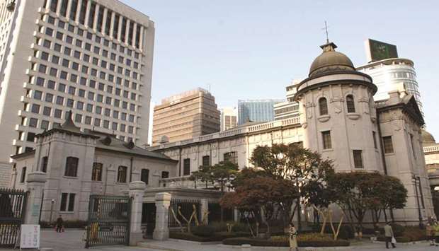 Pedestrians walk past in front of Bank of Koreau2019s headquarters in Seoul. The BoK raised its key interest rate for the first time in a year, choosing to prioritise heading off financial imbalances despite an uncertain economic outlook.