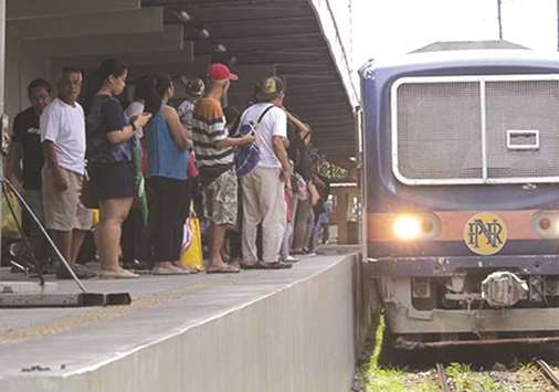 Commuters wait at a railway station.