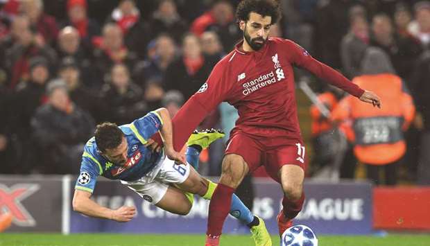 Liverpoolu2019s Mohamed Salah (right) runs past Napoliu2019s Mario Rui during the UEFA Champions League group C match at Anfield stadium in Liverpool. (AFP)