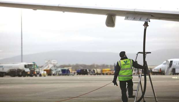 An employee stands beneath the wing of an aircraft as it is refueled at Dublin Airport. Making a presentation on IATAu2019s semi-annual report on the u201cEconomic performance of the airline industryu201d at the u2018Global Media Dayu2019 yesterday, chief economist Brian Pearce said jet fuel prices have fallen with oil prices and the global trade body of airlines has based its forecast on an average price of $81.3/b next year, and $65/b for the Brent crude oil price.