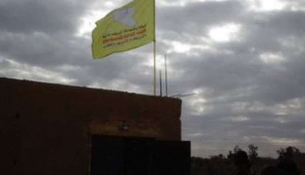 A screenshot from a vedio posted on Twitter that shows the flag of  Syrian Democratic Forces flying atop a building in Hajin.