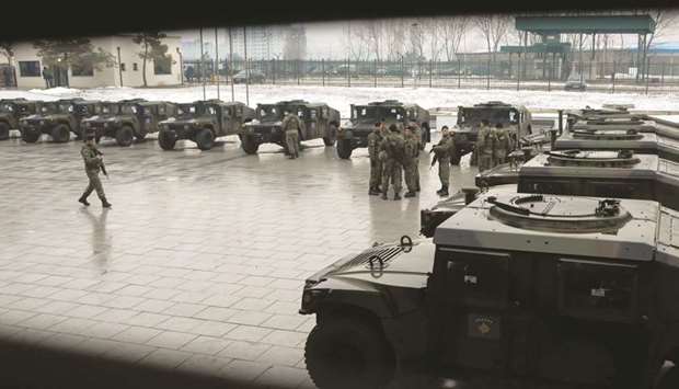 KSF personnel stand next to their vehicles after the army formation ceremony in Pristina.