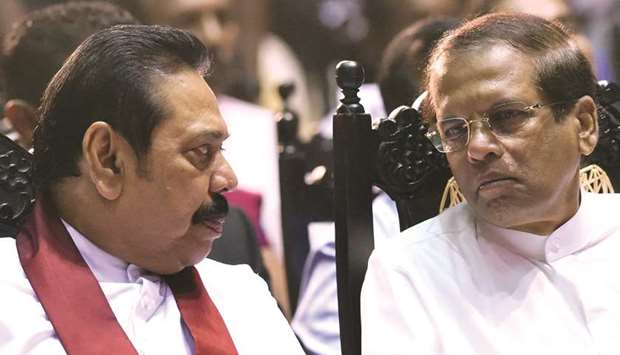 In this file photo, Sri Lankau2019s President Maithripala Sirisena, right, listens to currently-appointed prime minister Mahinda Rajapakse at a ceremony in Colombo.