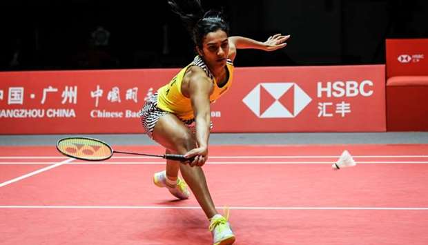 Sindhu Pusarla of India hits a return against Ratchanok Intanon of Thailand during their women's singles semi-final match at the 2018 BWF World Tour Finals badminton competition yesterday in Guangzhou in southern China's Guangdong province