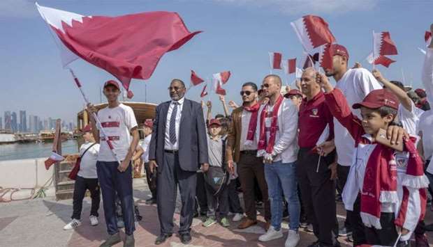 People participate in a Flag Relay on Doha Corniche.rnrn
