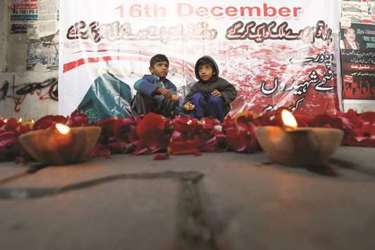Children hold oil lamps after lighting them with others during a vigil in Karachi to remember the victims of an attack on Peshawaru2019s Army Public School in 2014.