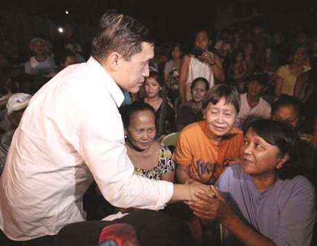 Former special assistant to the president Christopher Lawrence u2018Bongu2019 Go greets one of the fire victims in Barangay Holy Spirit, Quezon City.