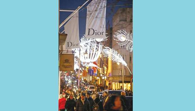 Festive lights decorate New Bond Street as people shop in central London yesterday.