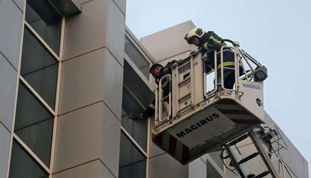 Firefighter breaks a glass window of a government hospital after it caught a fire in Mumbai
