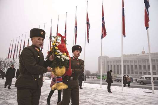Korean Peopleu2019s Army (KPA) soldiers carry flowers as they walk to pay their respects before the statues of late North Korean leaders Kim Il-sung and Kim Jong-il during National Memorial Day on Mansu Hill in Pyongyang. North Korea is marking the seventh anniversary of death of Kim Jong-il.