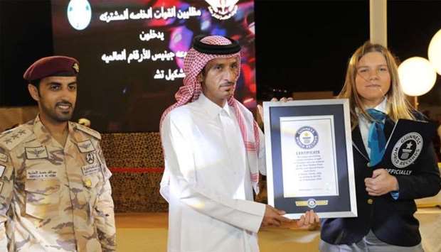 Major General Hamad bin Abdullah al-Fetais al-Marri receiving the Guinness emblem and certificaternr