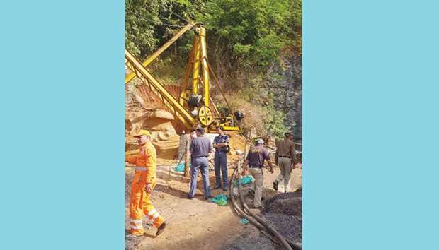 Emergency workers gather around a crane after 13 miners were trapped in an illegal coal mine in Ksan village in Meghalayau2019s East Jaintia Hills district.