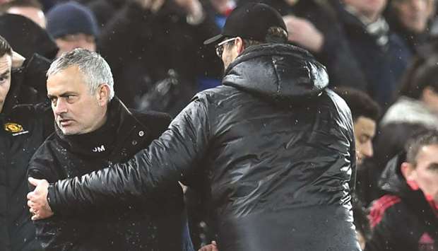 Manchester United manager Jose Mourinho (L) looks the other way while shaking hands with Liverpool manager Jurgen Klopp after their teamsu2019 EPL match on Sunday night.