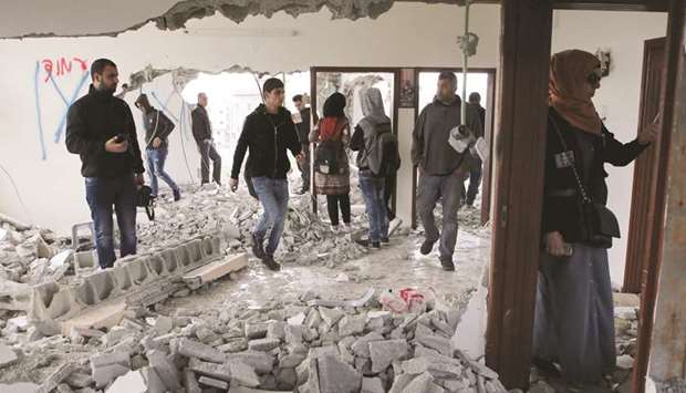 Palestinian people inspect the flat of Ashraf Naalwa after Israeli forces destroyed it in the village of Shuwaykah, near the West Bank city of Tulkarm, yesterday.