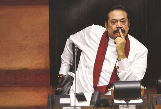 Mahinda Rajapakse, left, looks on during a parliament session after he was appointed the leader of the opposition in Colombo yesterday.