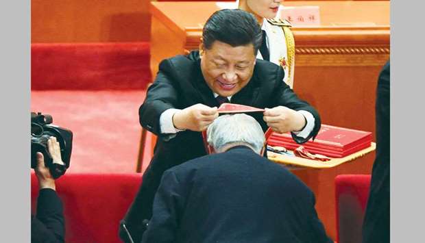 Chinau2019s President Xi Jinping awards a medal to an individual for his contribution to Chinau2019s development during a celebration meeting marking the 40th anniversary of Chinau2019s u201creform and opening upu201d policy at the Great Hall of the People in Beijing yesterday.