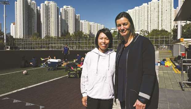 In this picture taken on December 17, 2018, France womenu2019s football team coach Corinne Diacre (R) and Eastern Football Club head coach Chan Yuen-ting pose after an Eastern team training session in Hong Kong. Trailblazing France coach Diacre said women in football face a constant struggle for acceptance and are often regarded as u201cobjectsu201d despite rising visibility and media coverage of female players.