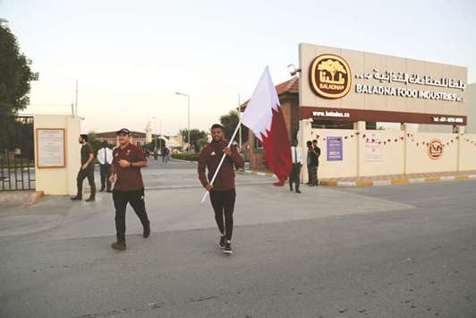 The QOC team carries the national flag.