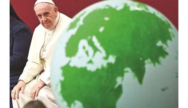 This picture taken on Saturday shows Pope Francis looking at a globe of the Earth during an audience for children and families of the Santa Marta dispensary at the Vatican.