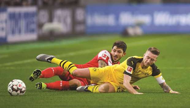 Fortuna Duesseldorfu2019s Matthias Zimmermann (left) and Dortmundu2019s Marco Reus vie for the ball during the Bundesliga match in Duesseldorf, western Germany, on Tuesday night. (AFP)