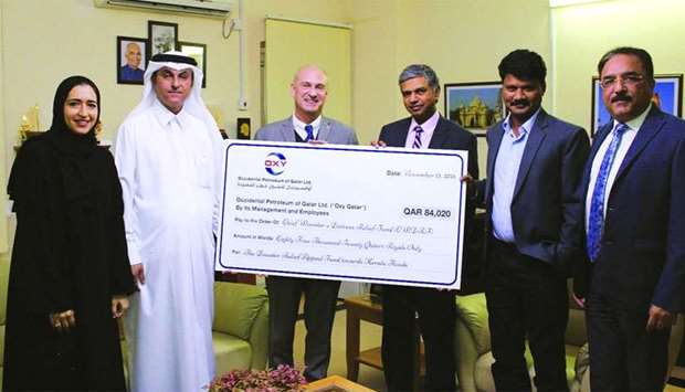 Oxy Qatar representatives hand over the cheque to the Indian ambassador P Kumaran