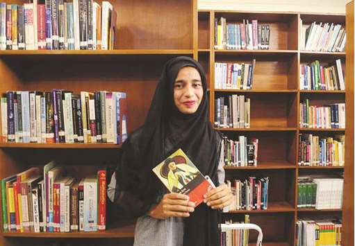 Formin Akter, a Rohingya refugee girl, holds a copy of the novel Jane Eyre, which she says is her new favourite book, inside the library of the Asian University for Women in Chittagong, Bangladesh.