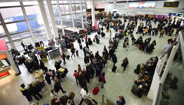 Passengers wait at London Gatwick Airport, south of London after all flights were grounded due to drones flying over the airfield