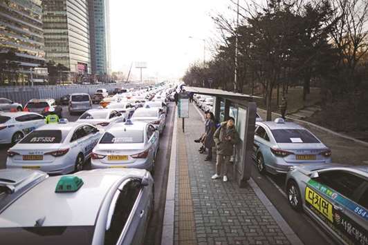 A bus stop is surrounded by hundreds of taxis parked to protest against a carpool service application launched by Kakao Corp in Seoul, South Korea.