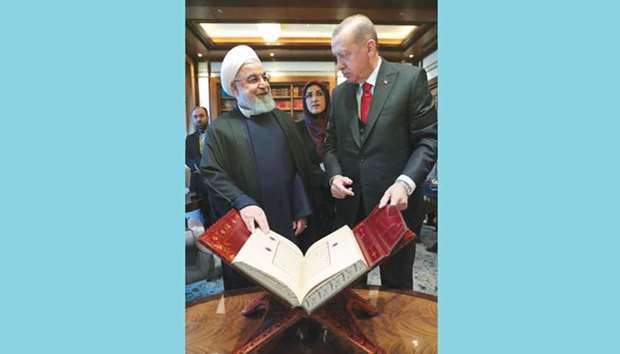 Turkeyu2019s President Recep Tayyip Erdogan offering a Holy Quru2019an to Iranu2019s President Hassan Rouhani after they chaired the Turkey-Iran High-Level Cooperation Council Meeting at Presidential Complex in Ankara.