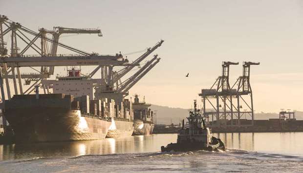 A tug boat heads out to retrieve a container ship at the Port of Oakland in California (file). The US economy slowed slightly more than previously estimated in the third quarter and momentum appears to have moderated further in the fourth quarter, with new orders and shipments of manufactured capital goods falling in November.