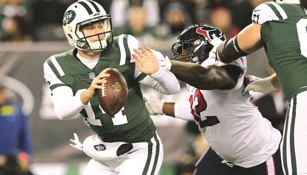 New York Jetsu2019 Sam Darnold (left) breaks free of pressure by Houston Texansu2019 Brandon Dunn during the first quarter of the NFL game in East Rutherford, New Jersey, on Saturday. (USA TODAY Sports)